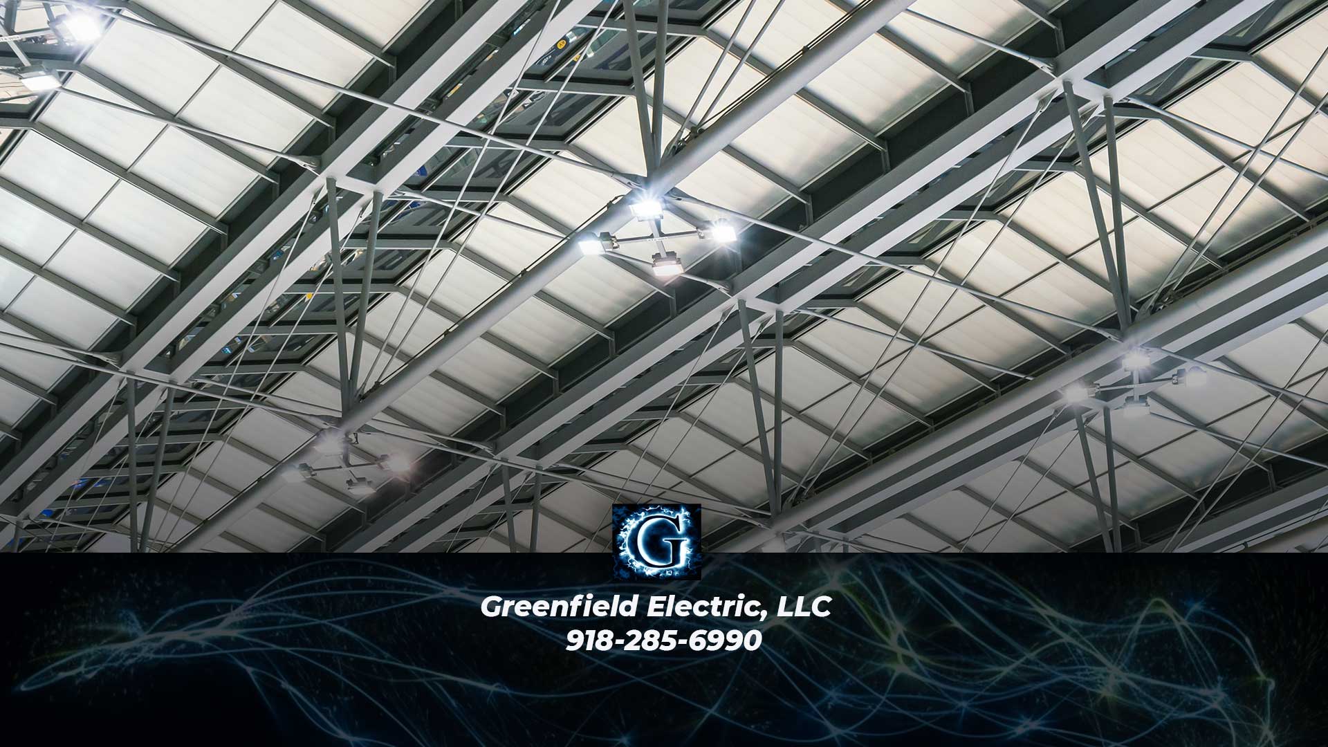 Nighttime photo of an wlectrical powerstation with Greenfield Electric, LLC logo